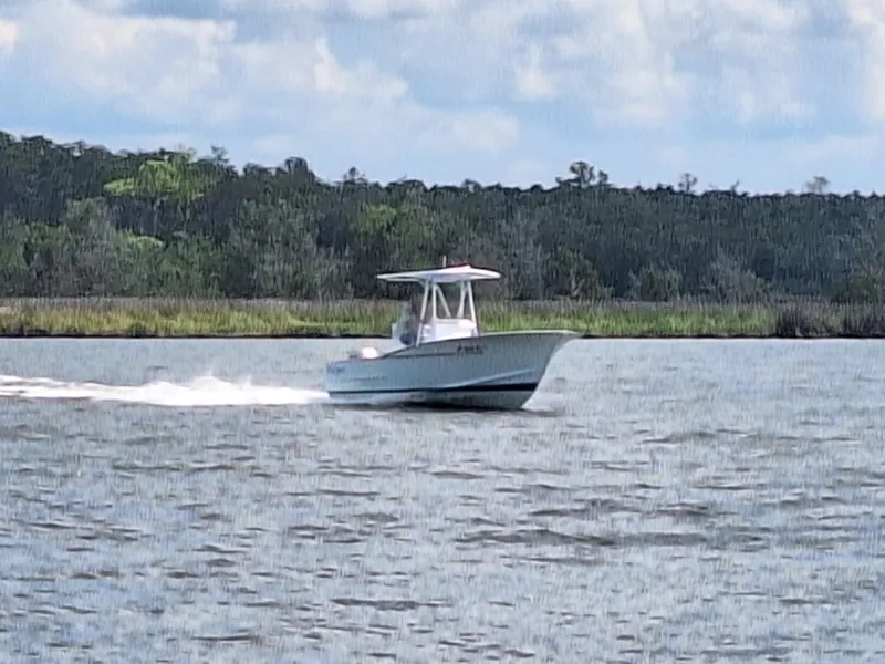 Slide: The Image of 2008 Custom Carolina boat cruising on a lake with forested shoreline in the background. - 7