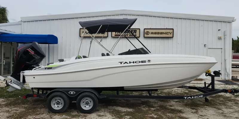 The Image of 2024 Tahoe T21 boat on trailer, parked outside dealership. - 0