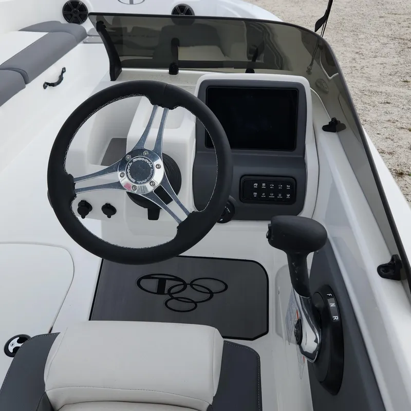 Slide: The Image of 2024 Tahoe T21 boat cockpit with steering wheel and control panel. - 2