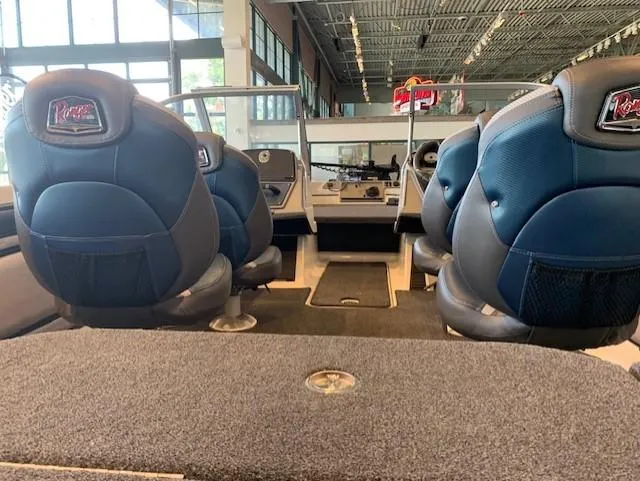 Slide: The Image of 2024 Ranger 1850MS boat interior with blue and black seats in showroom. - 4