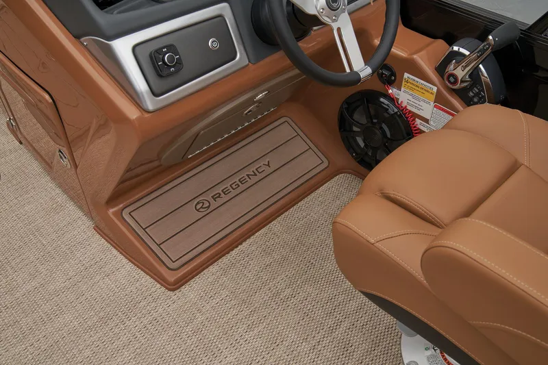 Slide: The Image of 2024 Regency 250 LE3 boat interior, tan leather seats, steering wheel, and control panel. - 28