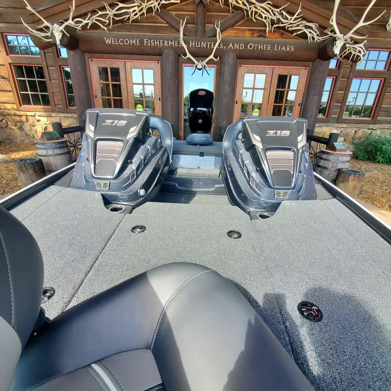 Slide: The Image of 2024 Nitro Z18 boat interior with dual seats, docked at a rustic lodge. - 3