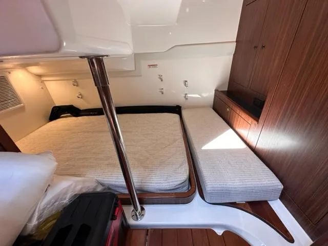 Slide: The Image of 2022 Pursuit OS 355 cabin interior with bed and wooden cabinetry. - 13
