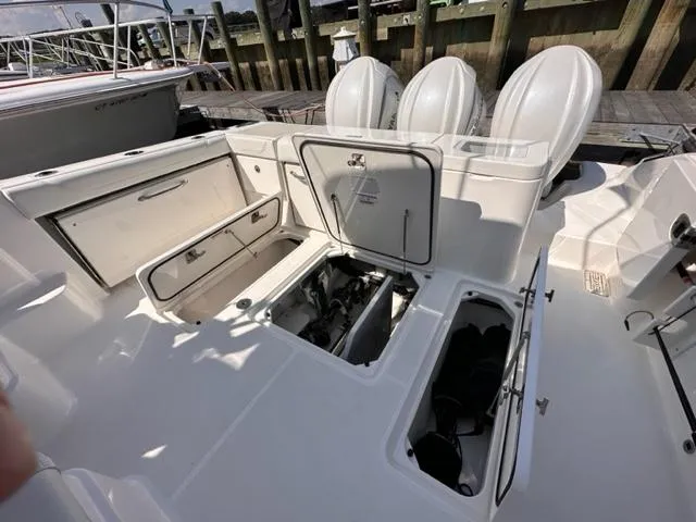 Slide: The Image of 2022 Pursuit OS 355 boat with open storage compartments and triple outboard engines. - 16