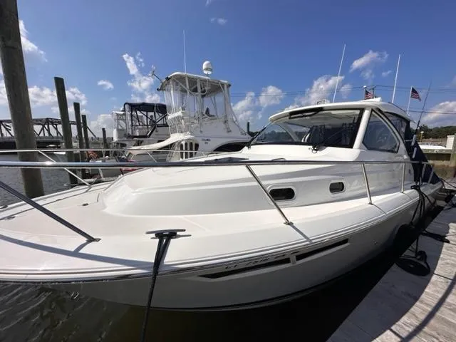 Slide: The Image of 2022 Pursuit OS 355 boat docked at a marina on a sunny day. - 18