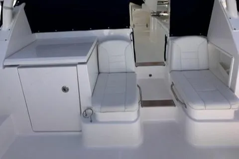 Slide: The Image of 2022 Pursuit OS 355 boat interior with white seating and storage compartments. - 24