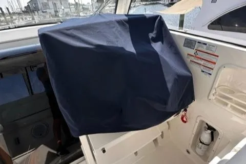 Slide: The Image of 2022 Pursuit OS 355 boat interior with covered equipment and safety features. - 31