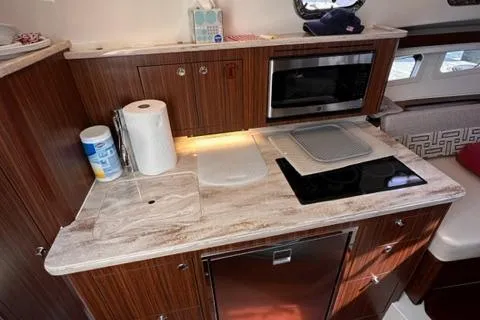 Slide: The Image of Modern kitchen area in 2022 Pursuit OS 355 boat with microwave and stovetop. - 34