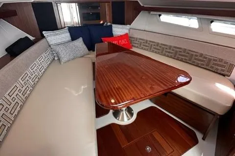 Slide: The Image of 2022 Pursuit OS 355 cabin interior with wooden table and cushioned seating. - 39