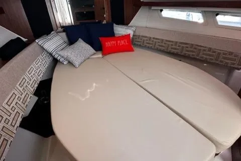 Slide: The Image of Interior cabin of 2022 Pursuit OS 355 boat with cozy bed and decorative pillows. - 40