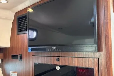 Slide: The Image of Flat-screen TV and microwave in 2022 Pursuit OS 355 boat interior. - 42