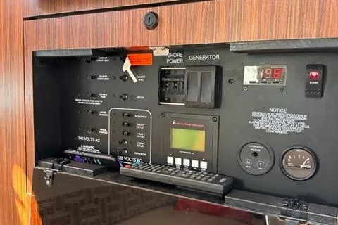 Slide: The Image of Control panel of a 2022 Pursuit OS 355 boat with shore power and generator switches. - 43