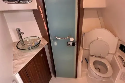 Slide: The Image of 2022 Pursuit OS 355 boat bathroom with glass sink and toilet. - 44