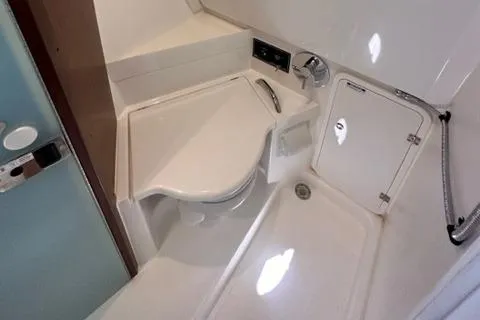 Slide: The Image of 2022 Pursuit OS 355 boat bathroom with compact sink and shower. - 45