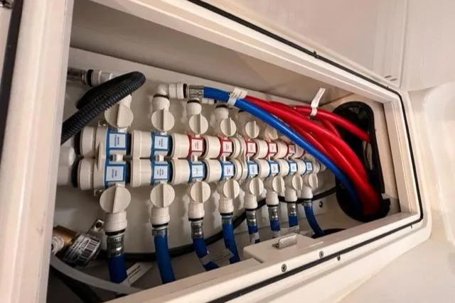Slide: The Image of Pursuit OS 355 2022 boat plumbing system with labeled valves and colored hoses. - 47