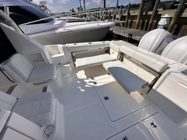 Slide: The Image of 2022 Pursuit OS 355 boat with white seating and spacious deck at a marina. - 8