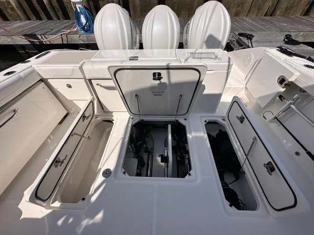 Slide: The Image of 2022 Pursuit OS 355 boat with open storage compartments and engine access. - 9