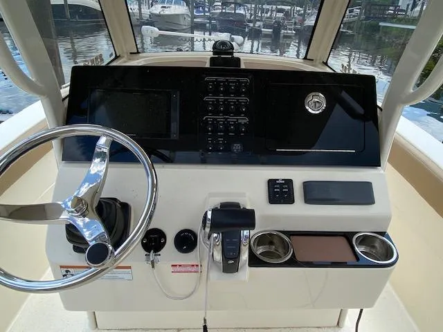 Slide: The Image of 2020 Scout 235 XSF boat dashboard with steering wheel and control panel. - 17