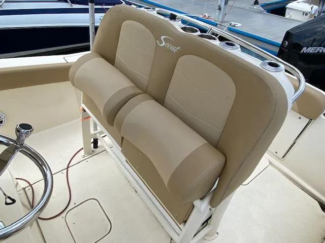 Slide: The Image of 2020 Scout 235 XSF boat with beige cushioned seating and steering wheel. - 19