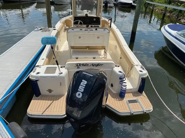 Slide: The Image of 2020 Scout 235 XSF boat docked, featuring a Mercury outboard motor. - 2