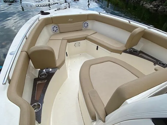 Slide: The Image of 2020 Scout 235 XSF boat interior with beige seating and cup holders. - 20
