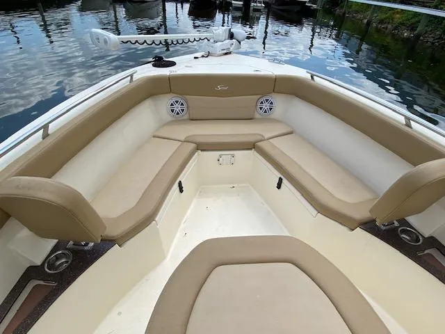 Slide: The Image of 2020 Scout 235 XSF boat with tan seating and white interior, docked by the water. - 21