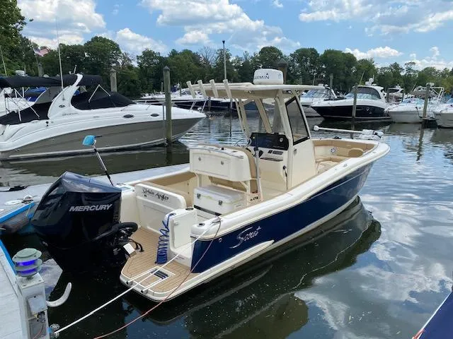 Slide: The Image of 2020 Scout 235 XSF boat docked in a marina with other boats. - 3