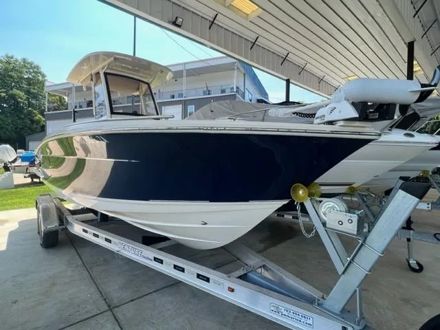 Slide: The Image of 2020 Scout 235 XSF boat on trailer under a covered dock. - 4