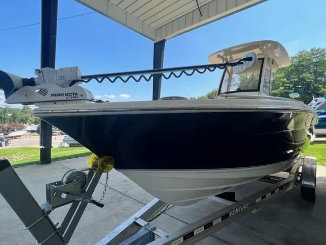 Slide: The Image of 2020 Scout 235 XSF boat on trailer under a canopy. - 5