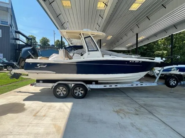 Slide: The Image of 2020 Scout 235 XSF boat on a trailer under a covered area. - 7