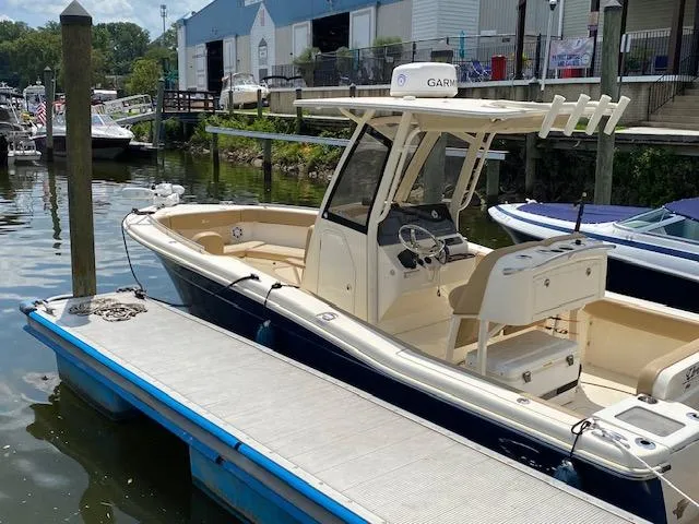 Slide: The Image of 2020 Scout 235 XSF boat docked at a marina. - 9