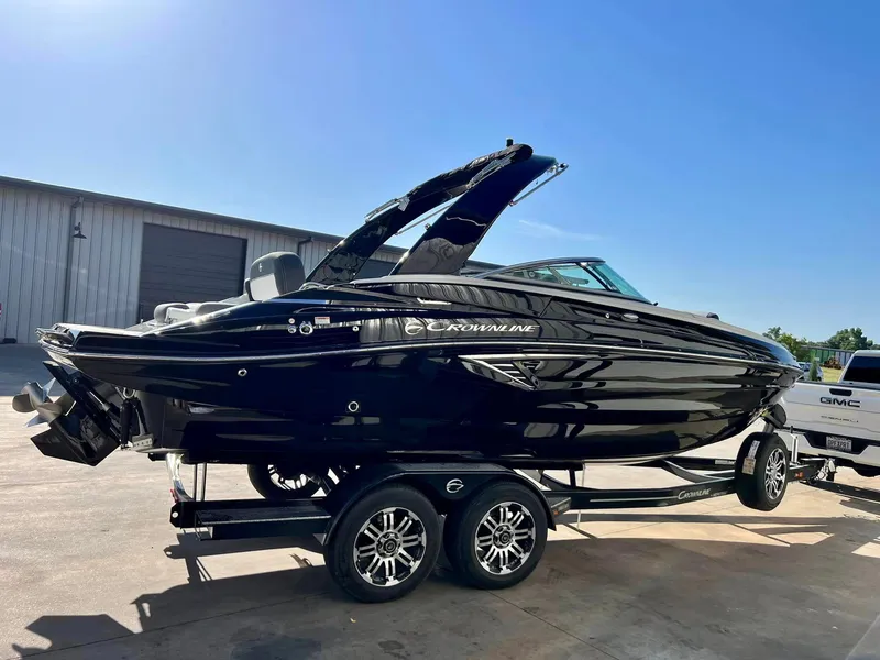 Slide: The Image of 2024 Crownline 260SS boat on a trailer, black exterior, parked outdoors. - 1