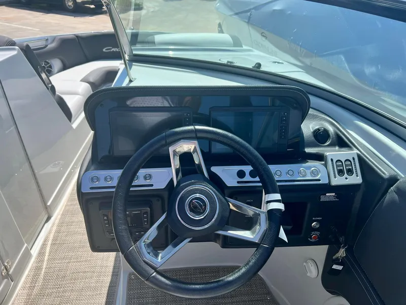 Slide: The Image of 2024 Crownline 260SS boat dashboard with steering wheel and control panel. - 11