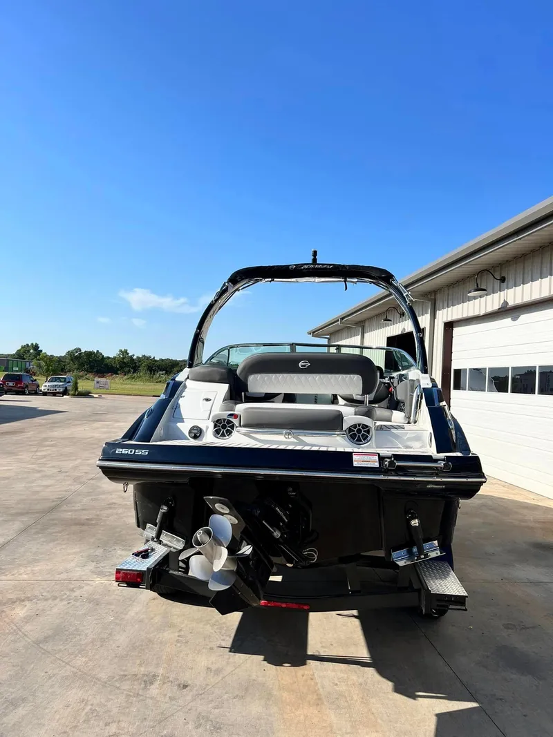Slide: The Image of 2024 Crownline 260SS boat at a dockyard under a clear blue sky. - 2