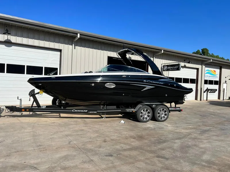 Slide: The Image of 2024 Crownline 260SS boat on a trailer outside a warehouse. - 7