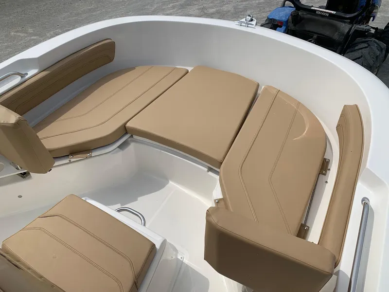 Slide: The Image of 2024 Bayliner Trophy 20 CC boat with tan cushioned seating. - 7