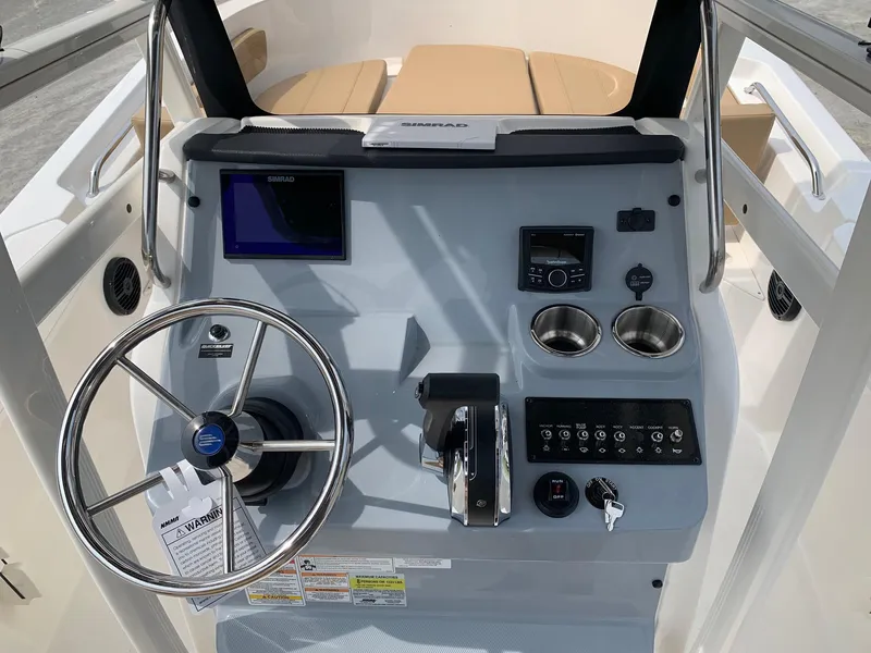 Slide: The Image of 2024 Bayliner Trophy 20 CC boat console with steering wheel, controls, and navigation display. - 14