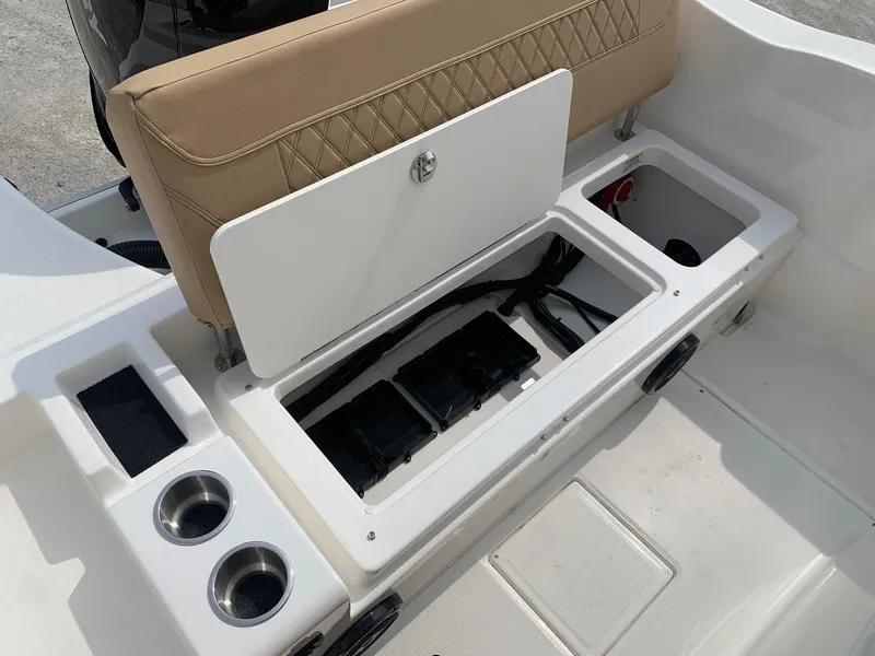 Slide: The Image of 2024 Bayliner Trophy 20 CC boat storage compartment with cup holders and cushioned seat. - 16