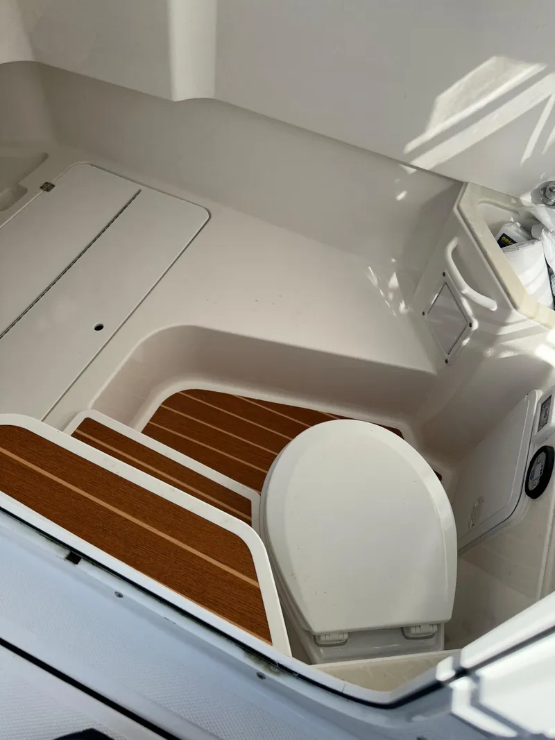 Slide: The Image of 2022 Edgewater 280 CC boat interior with wooden steps and toilet. - 11