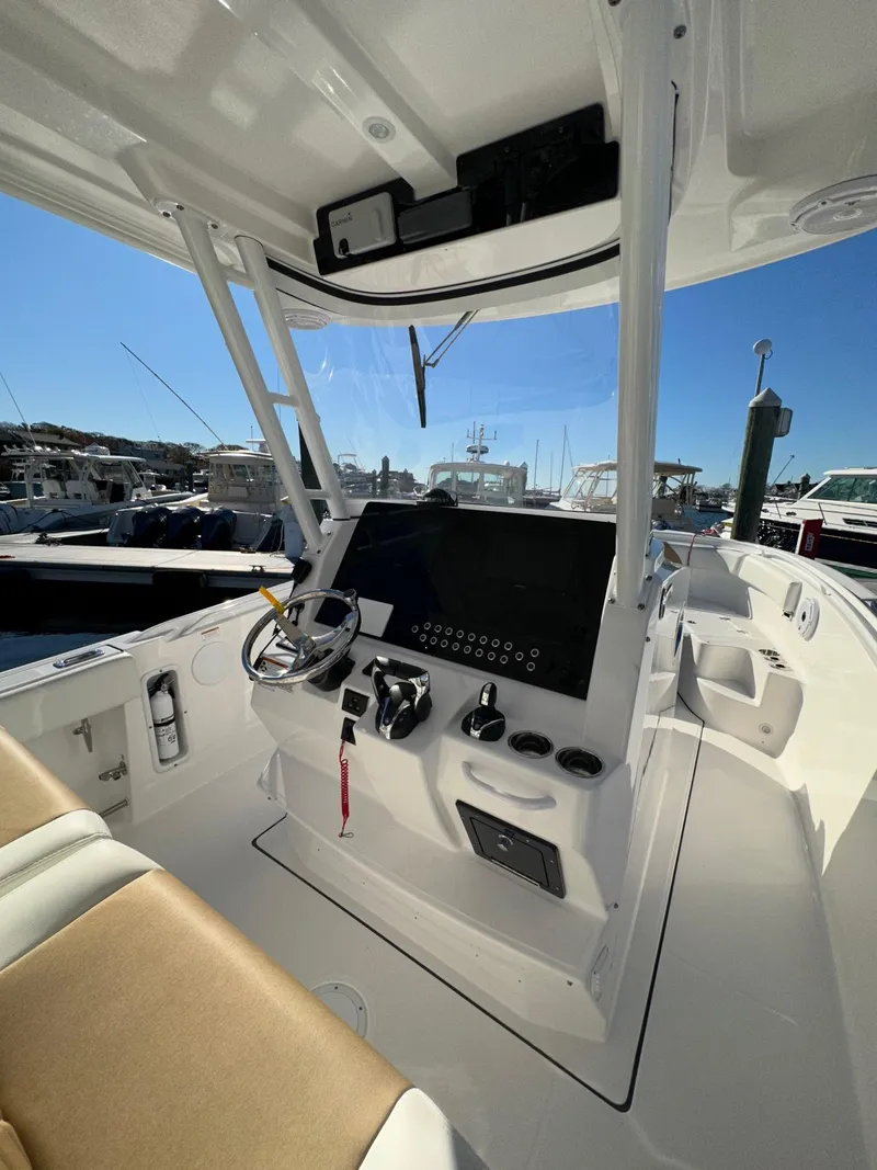 Slide: The Image of Interior helm of a 2022 Edgewater 280 CC boat with modern controls and seating. - 8