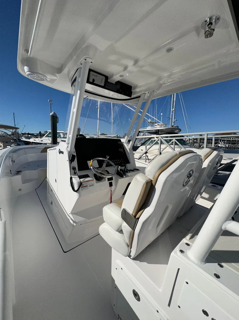 Slide: The Image of 2022 Edgewater 280 CC boat interior with helm station and seating. - 9