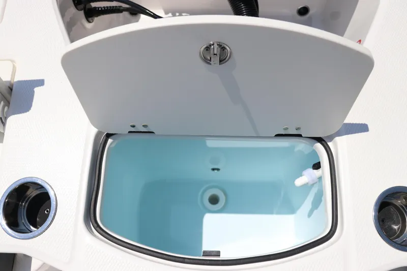 Slide: The Image of 2024 Robalo 206 Cayman boat livewell with open lid, showcasing interior features. - 12