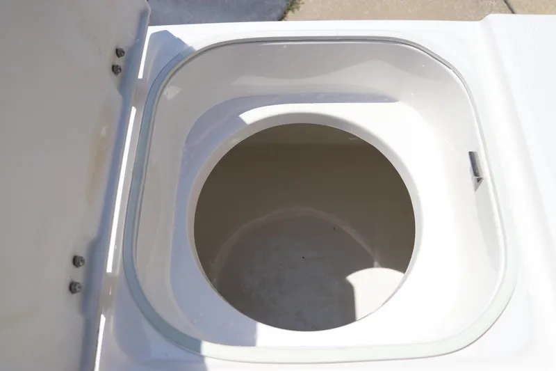Slide: The Image of 2024 Robalo 206 Cayman boat storage compartment, open lid, white interior. - 18