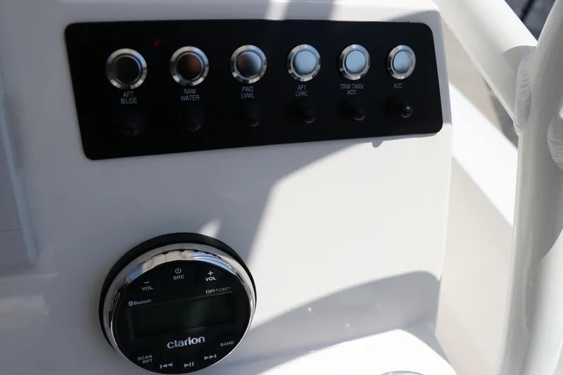 Slide: The Image of Control panel of 2024 Robalo 206 Cayman boat with switches and Clarion audio system. - 26