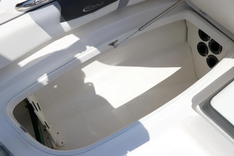 Slide: The Image of 2024 Robalo 206 Cayman boat interior storage compartment with rod holders. - 30