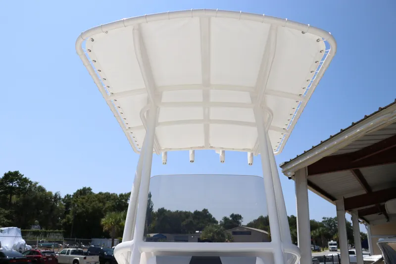 Slide: The Image of 2024 Robalo 206 Cayman boat with T-top, viewed from below, against a clear blue sky. - 39
