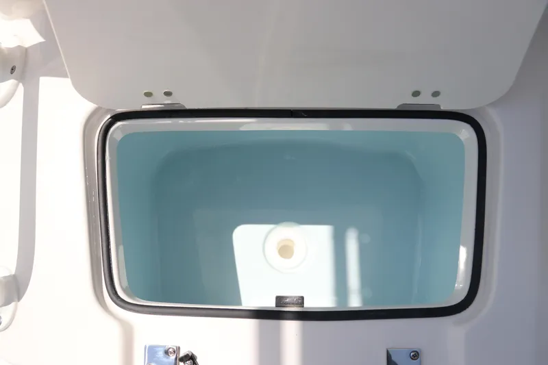 Slide: The Image of 2024 Robalo 206 Cayman boat storage compartment, open lid, white interior. - 41