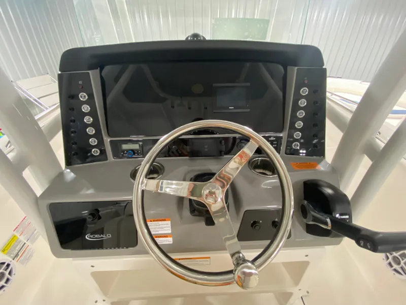 Slide: The Image of 2024 Robalo R230 Center Console boat dashboard with steering wheel and control panel. - 10
