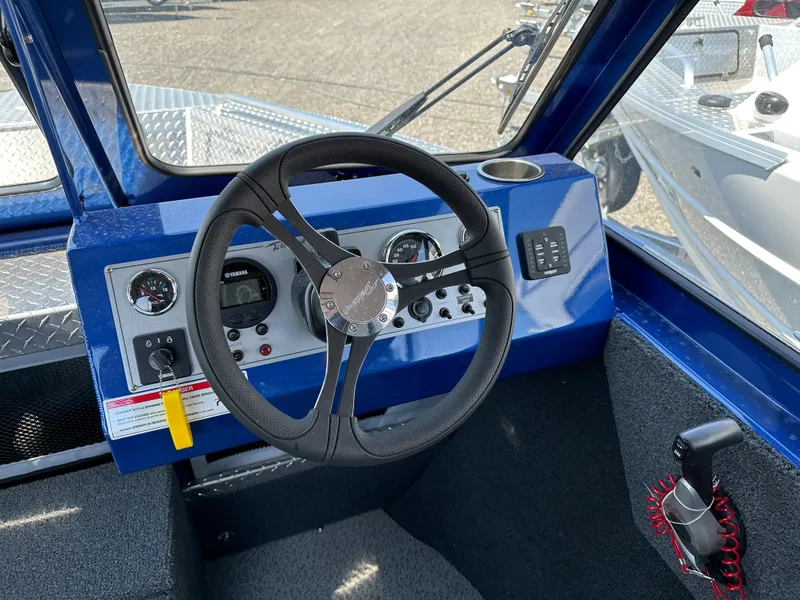 Slide: The Image of 2024 Weldcraft 220 Maverick boat dashboard with steering wheel and control panel. - 4