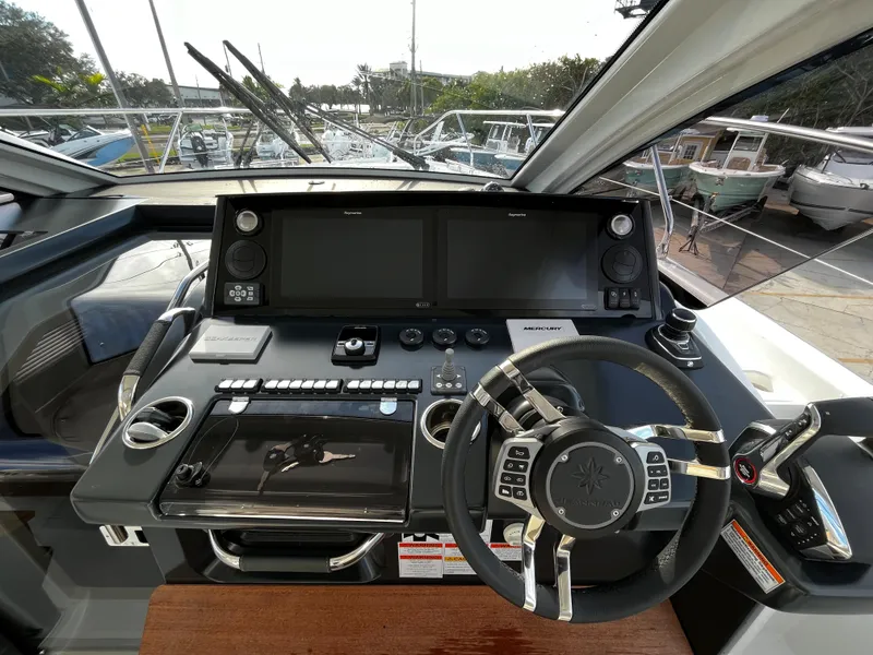 Slide: The Image of 2024 Jeanneau DB/43 OB helm station with advanced navigation controls and dual displays. - 13